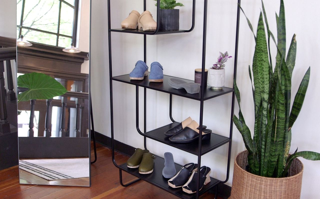 A black metal shelf with 3D printed shoes on it